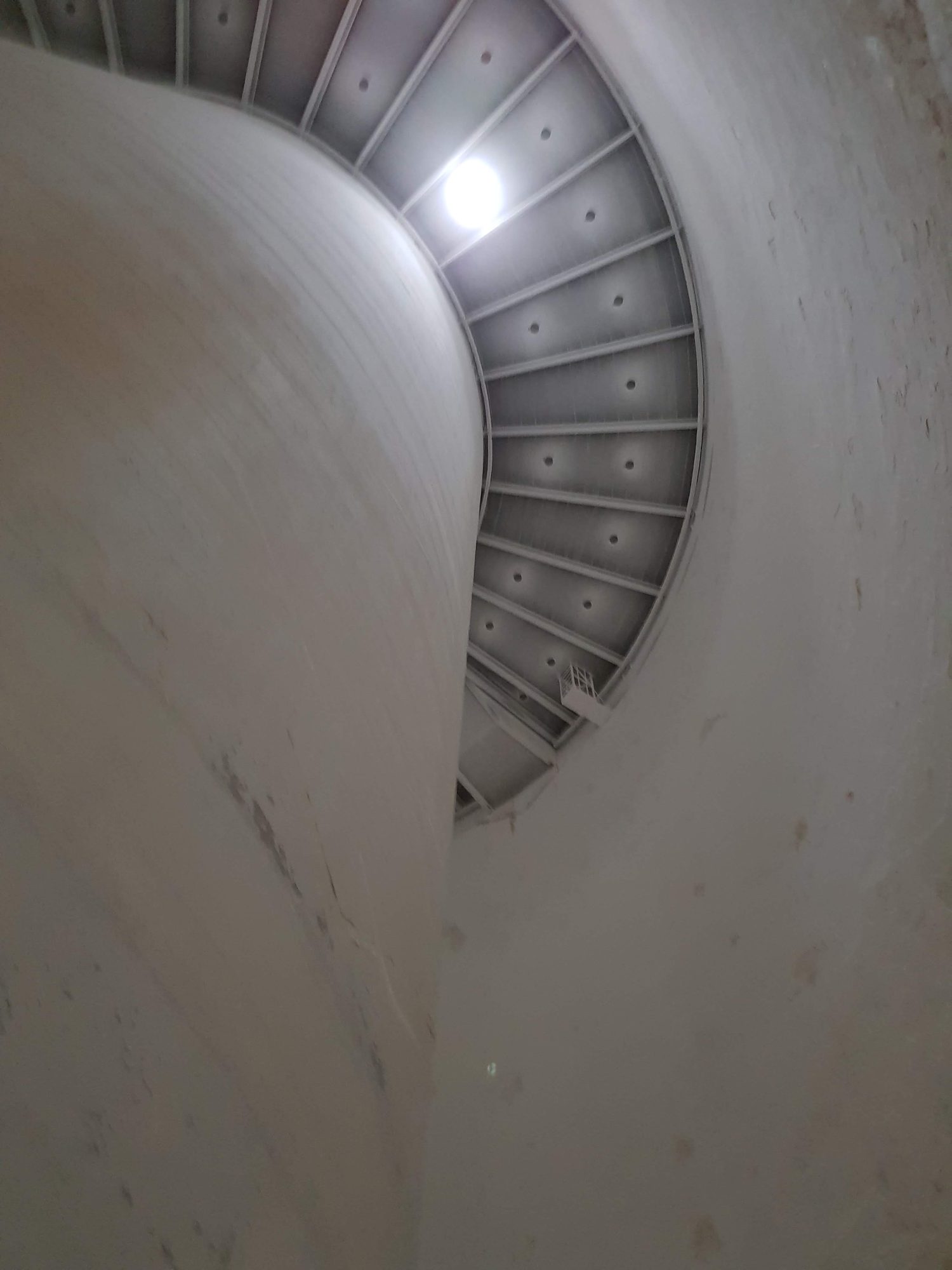 Blick im Inneren einer Silozelle an der Wand entlang nach oben zum hellen Auslass