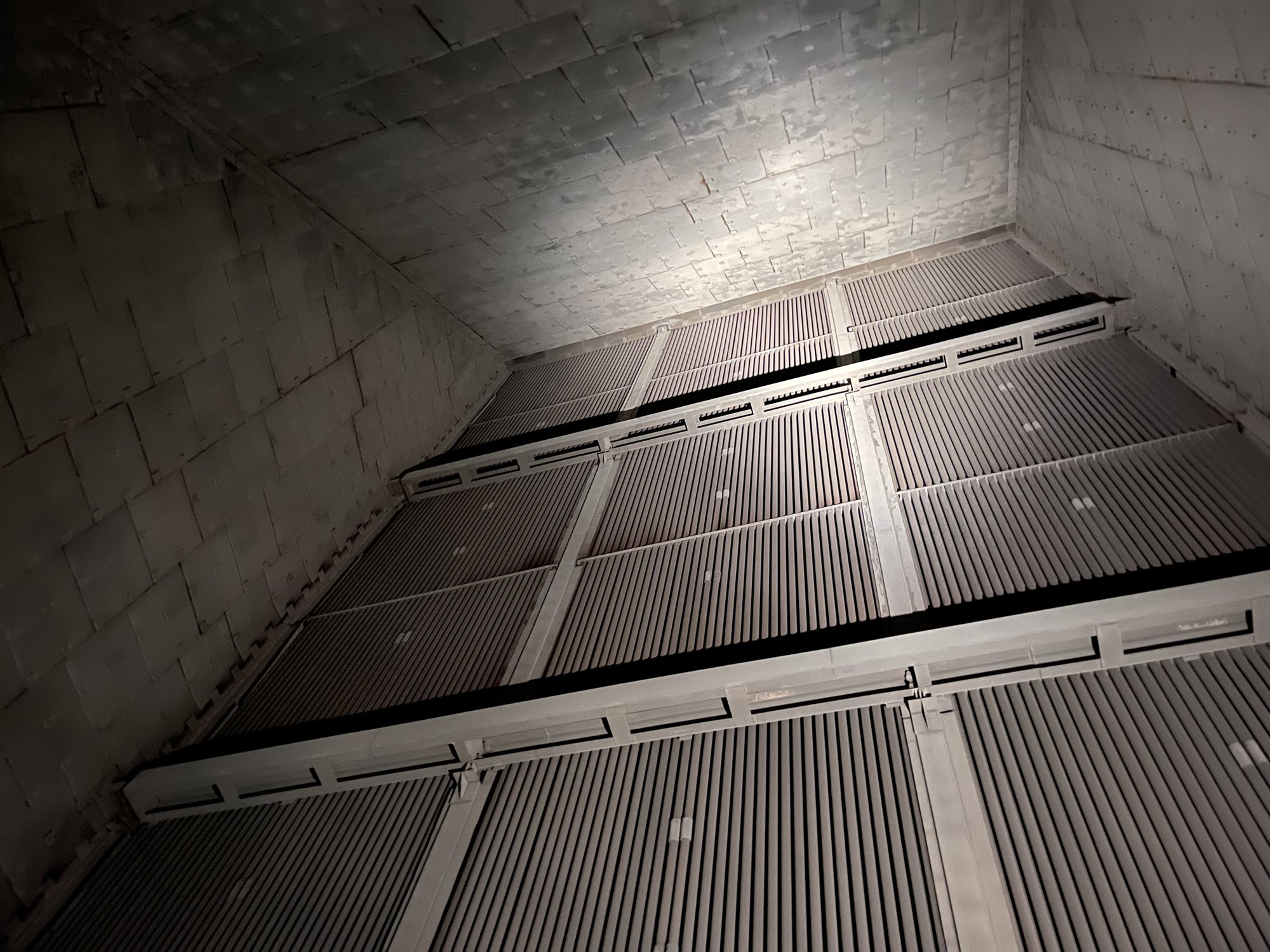 Blick von unten in einen Wärmetauscher eines Gaskraftwerks: Rohrbündel zwischen Stahlträgern, darüber die verkleidete Gehäusewand