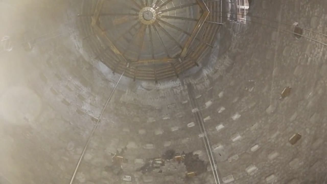 Blick im leeren Hochofen nach oben: ausgemauerte Wand, oben eine Stahlkonstruktion