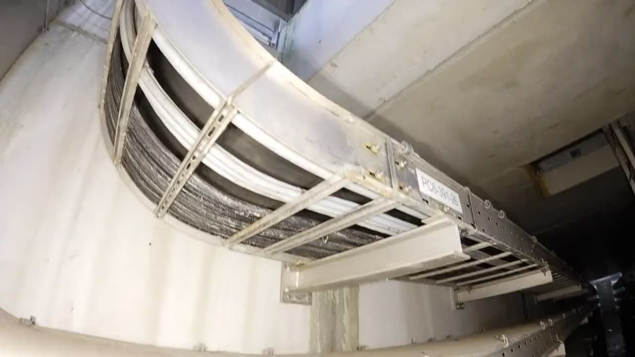 Drohnenflug durch einen unterirdischen Kabelkanal mit Kabeltrassen auf beiden Seiten