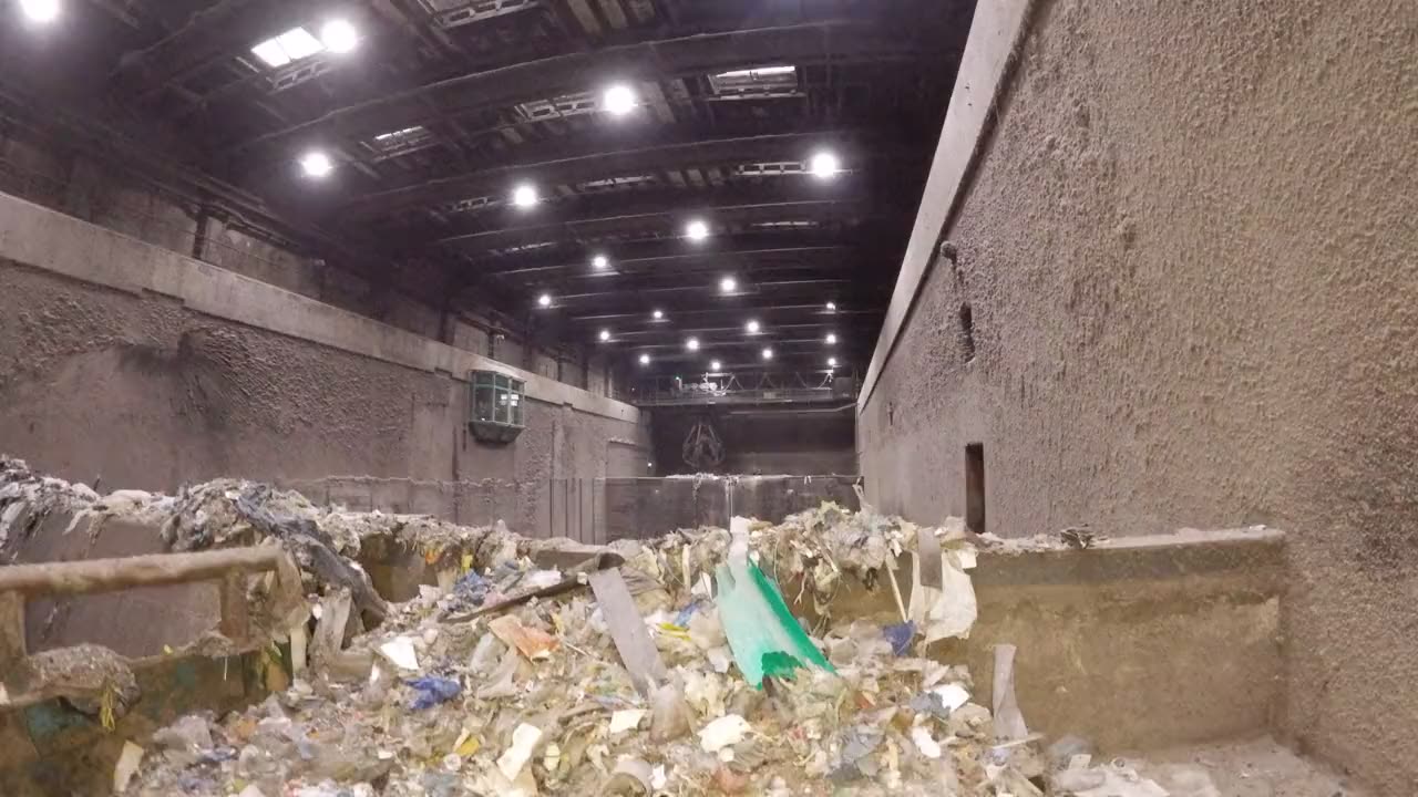Drohnenflug in die Bunkerhalle mit Deckenlicht, Kran und Abfall am Boden