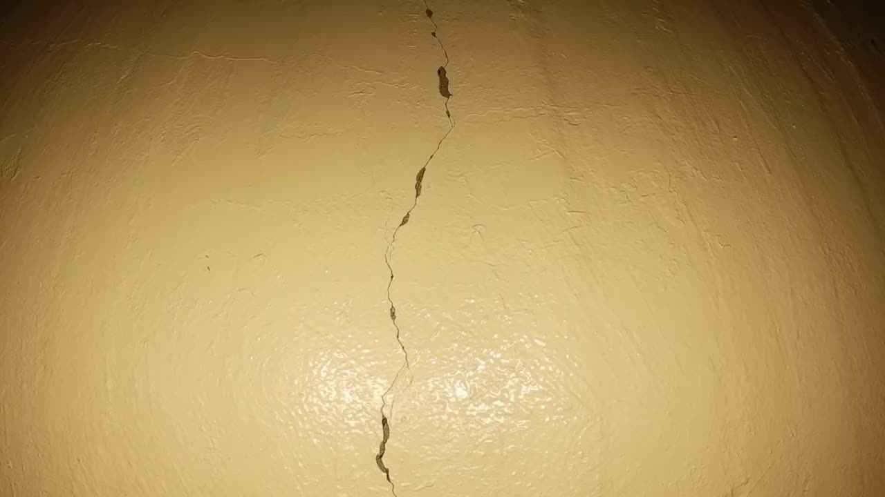 Nahaufnahme eines senkrechten Risses in der beschichteten Silowand